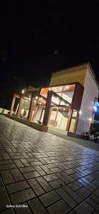 a building at night with a cobblestone street in front at LGR Club House in Poringalkuthu
