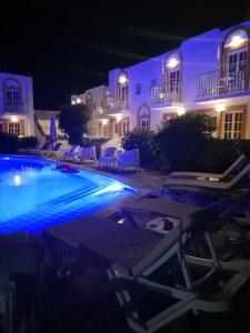 a swimming pool in front of a building at night at Katerina Apartments in Kalymnos