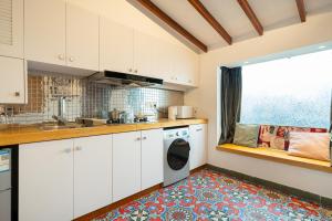 cocina con armarios blancos y lavadora en Shanghai Hills & Serendipity Roof House en Shanghái