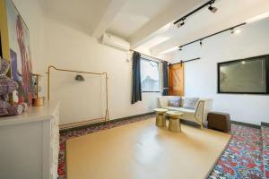 a living room with a couch and a table at Shanghai Hills & Serendipity Roof House in Shanghai