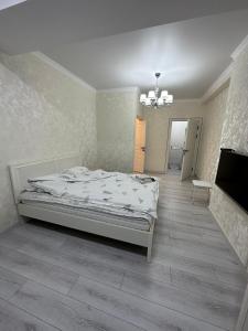 Schlafzimmer mit einem Bett und einem Kronleuchter in der Unterkunft Уметалиева in Bischkek