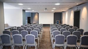 an empty room with chairs and a white screen at Park Hotel Almaty in Almaty