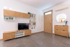 sala de estar con TV y puerta en CaseOspitali - CASA KLIMT rinnovato bilocale in centro storico per 4 pax, en Cernusco sul Naviglio