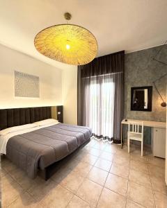 a bedroom with a large bed and a large chandelier at Villa Liliana in Cervia