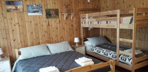 ein Schlafzimmer mit einem Bett und einem Etagenbett in der Unterkunft Monolocale Il Capriolo - Abetone in Abetone