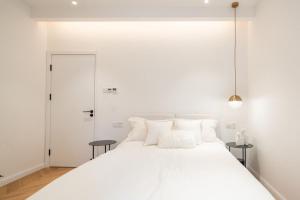 a white bedroom with a large white bed with white pillows at Shanghai Hills & Serendipity Homestay in Shanghai