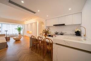 a kitchen with white cabinets and a table and chairs at Shanghai Hills & Serendipity Homestay in Shanghai