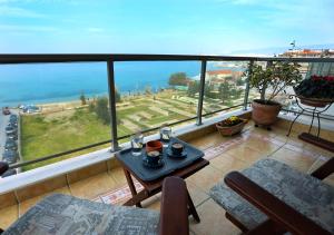 uma varanda com uma mesa e vista para o oceano em Seafront Family Apartment & free parking, the Cruiseflat em Tessalônica