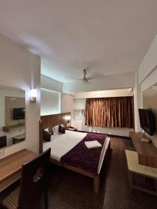a bedroom with a bed and a desk and a television at Hotel Twins Residency in Thane