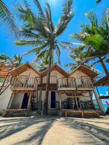 un complejo en la playa con palmeras en Pipa de Playa Resort Café, en Gubat