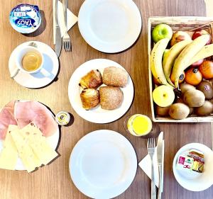 una mesa con platos de comida y una caja de fruta en The Hollywood Hotel Cannes en Cannes