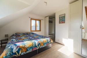 een slaapkamer met een bed met een kleurrijke deken bij La maison d'Alphonse : Plouha, proche de la plage in Plouha
