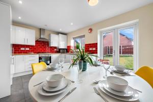 a kitchen and dining room with a white table and chairs at 4BR Contractor House in Birmingham w/Parking in West Bromwich