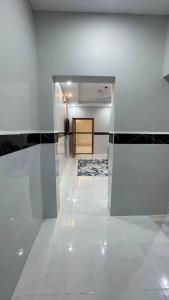 una camera con corridoio con piastrelle bianche e nere di سحاب الأندلس للأجنحة الفندقية - املج a Umm Lajj