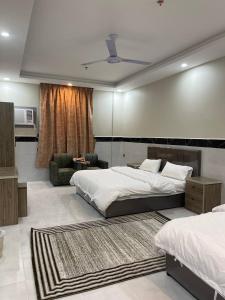 a bedroom with two beds and a living room at سحاب الأندلس للأجنحة الفندقية - املج in Umm Lujj