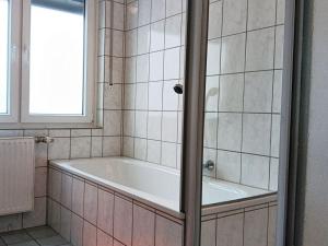 La salle de bains carrelée est pourvue d'une baignoire et d'une fenêtre. dans l'établissement Abendsonne Obergeschoss mit Balkon, à Coblence