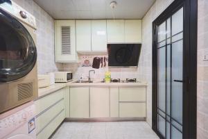 una pequeña cocina con armarios blancos y fregadero en Shanghai Hills & Well-time Memphis B&B en Shanghái
