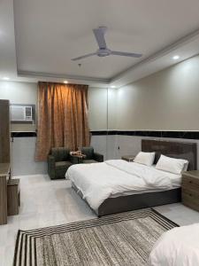 a bedroom with a large bed and a living room at سحاب الأندلس للأجنحة الفندقية - املج in Umm Lujj
