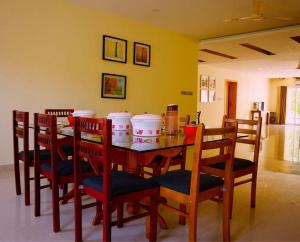 uma sala de jantar com mesa e cadeiras em Lynwood Villa - Pet Friendly em Kelambākkam