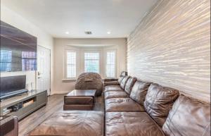 uma sala de estar com um sofá grande e uma televisão em Gorgeous DTLA w/ View + Hot Tub! em Los Angeles