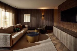 a living room with a couch and a tv at Van der Valk Hotel Groningen Zuidbroek in Zuidbroek