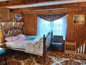 - une chambre avec un lit, une chaise et une fenêtre dans l'établissement Domek nad jeziorem w otulinie lasu, à Bartołty Wielkie