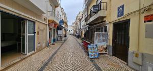 un callejón con edificios y tiendas en una calle en SUNAO, en Nazaré