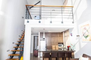 a kitchen and staircase in a loft with white walls at Eden on the Bay Luxury Apartments, Blouberg, Cape Town in Bloubergstrand