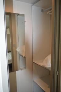 um armário com portas de vidro e um espelho em mobil home em Sainte-Reine-de-Bretagne