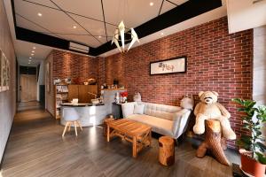 a living room with a brick wall and a couch and a teddy bear at Meets Anping in Anping