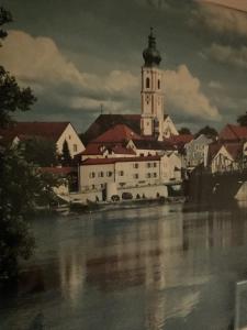 ein Gebäude mit einem Turm und einer Kirche neben einem Fluss in der Unterkunft Auenwald in Roding