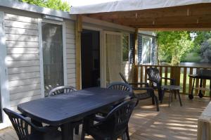 a patio with a table and chairs on a deck at mobil home in Sainte-Reine-de-Bretagne
