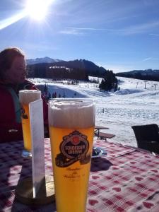 dois copos de cerveja sentados numa mesa numa pista de esqui em Ferienwohnung Gilch em Oberwössen