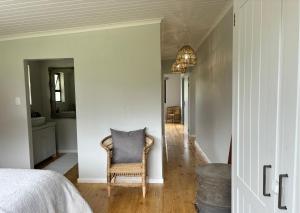 Habitación con cama, silla y pasillo en Oakhurst Farm Cottages, en Wilderness