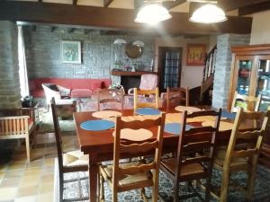 a dining room with a wooden table and chairs at logoden in Paimpont