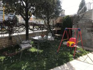 a yard with two swings and a swing at New and spacious accommodation in Ioannina! in Ioannina