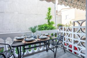 a table with plates and glasses on a balcony at Flamingo deluxe studio in Pefkochori