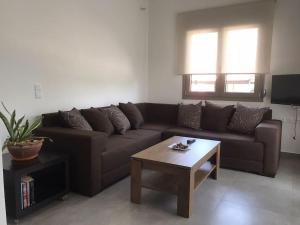 a living room with a brown couch and a coffee table at New and spacious accommodation in Ioannina! in Ioannina