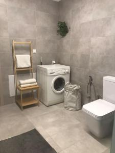 a bathroom with a washing machine and a toilet at New and spacious accommodation in Ioannina! in Ioannina