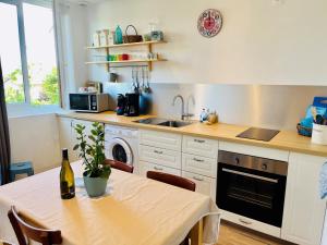 a kitchen with a table with a bottle of wine on it at Gîtes du Fort in Collonges +8 photos
