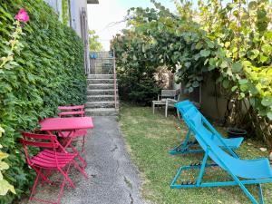 une table et des chaises colorées dans un jardin dans l'établissement Le Credo, à Collonges