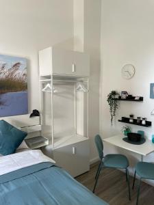 a bedroom with a bed and a desk and chairs at Ferienwohnung kleine Strandperle in Norderney