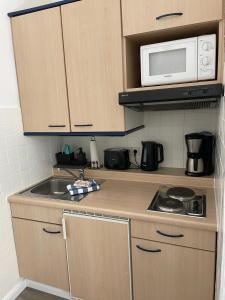 a small kitchen with a sink and a microwave at Ferienwohnung kleine Strandperle in Norderney