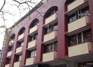 a red brick building with many windows at Nahar Heritage Hotel in Bengaluru