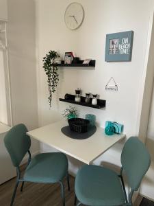 a table with two chairs and a clock on a wall at Ferienwohnung kleine Strandperle in Norderney +2 photos