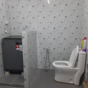 uma casa de banho com um WC e um chuveiro em Hidden Homestay em Marang