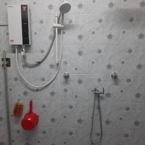 a bathroom with a shower and a shower head at Hidden Homestay in Marang