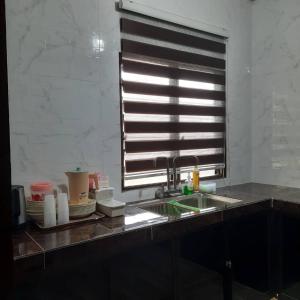 cocina con fregadero y ventana en Hidden Homestay, en Marang