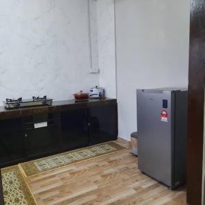 a kitchen with a stainless steel refrigerator in a room at Hidden Homestay in Marang
