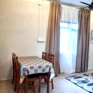 a table and chairs in a room with a window at Hidden Homestay in Marang
